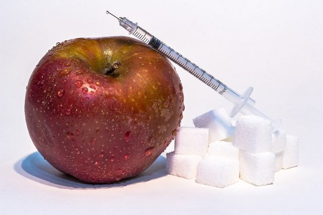 Insulin syringe, apple, sugar